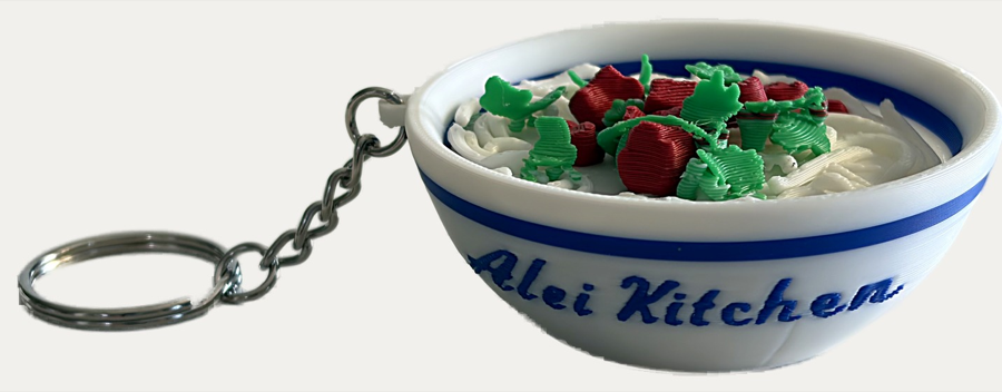 The same dish modelled in three dimensions as a small noodle bowl on a keychain chain.